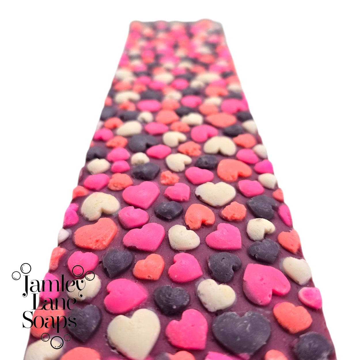 up close texture of the impression left by the hearts of love impression mat. multicolor bubble hearts on top of a loaf of soap