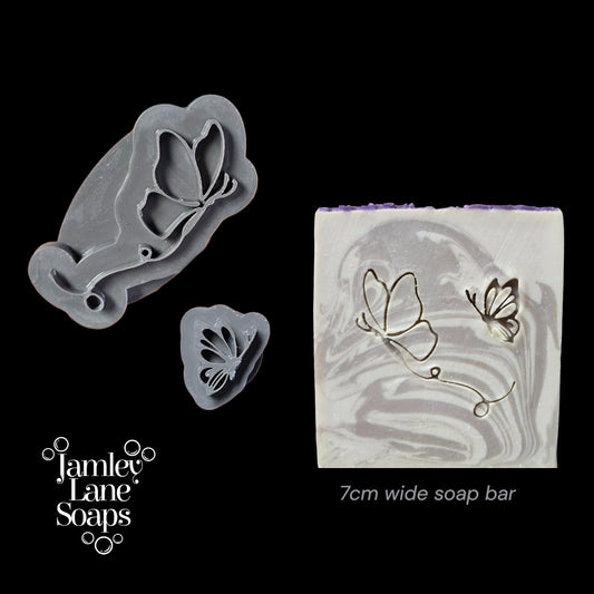Butterfly-themed soap stamp and soap bar with 'Jamey Lane Soaps' branding on a black background.