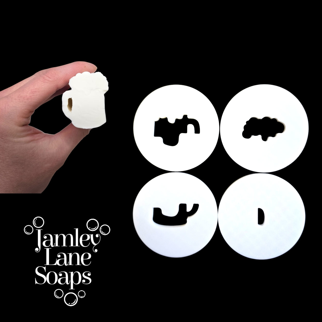 Hand holding a white soap mug embed with four circular discs featuring different shapes on a black background, branded 'Jamley Lane Soaps'.