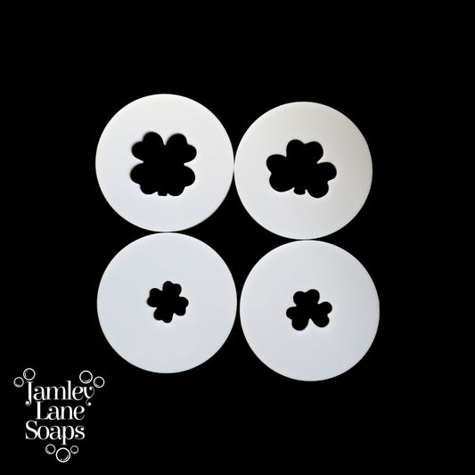 Four white circular discs with four-leaf clover designs on a black background, featuring Jamley Lane Soaps branding.