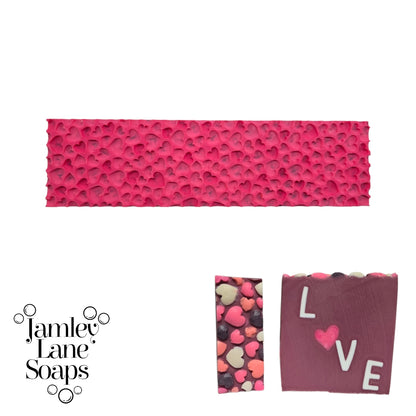 Pink textured impression mat and 2 soap bars cut for sizing. Showcasing the heart pattern and 'LOVE' text, branded as Jamley Lane Soaps.